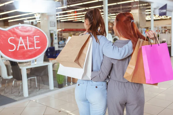 二人の女性が一緒に買い物を楽しみ 買い物袋を持って 店のディスプレイを見てのリアビューショット — ストック写真