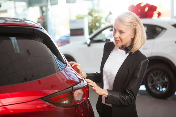 Donna Affascinante Esaminando Bella Auto Rossa Vendita Presso Concessionaria — Foto Stock