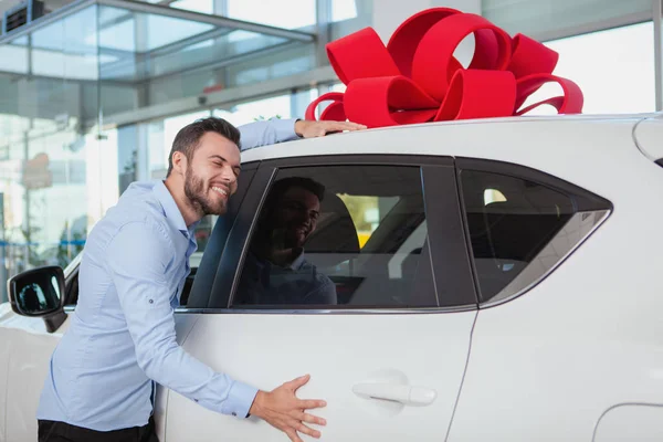 Homem Bonito Feliz Abraçando Seu Carro Novo Concessionária Excitado Motorista — Fotografia de Stock