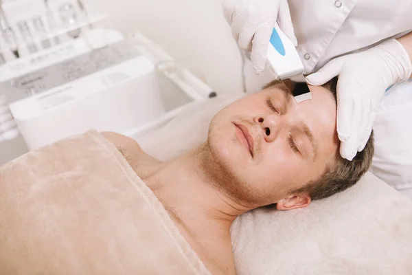 Bonito Homem Recebendo Tratamento Limpeza Facial Ultra Som Por Cosmetologista — Fotografia de Stock