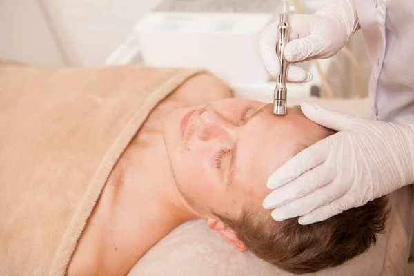 Cosmetologist Profissional Que Aperta Pele Cliente Masculino Com Dispositivo Ultrassônico — Fotografia de Stock