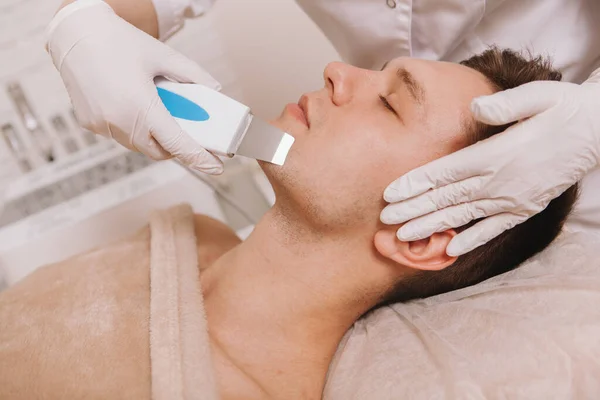 Nierozpoznawalny Kosmetolog Korzystający Ultradźwiękowego Urządzenia Pielęgnacji Skóry Czyszczący Skórę Męskiego — Zdjęcie stockowe
