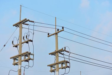 Güç iletim sistemiyle gökyüzü ve parlak gün güzel bulutlarda. Elektrik direkleri ve güç hatları. Fiber optik sistemi Internet iletişim sistemi güç kutuplarda