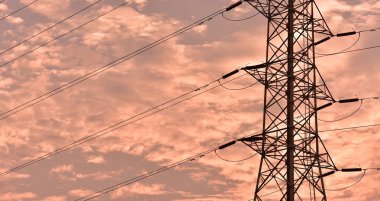 Gün batımında güzel gökyüzü ile yüksek güçlü enerji nakil direkleri.