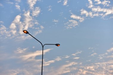 Elektrik sokak aydınlatma ve sarı gökyüzü sabahın erken saatlerinde.