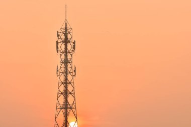 Kablosuz iletişim anteni ile parlak gökyüzü. Turuncu gökyüzü antenler ile telekomünikasyon Kulesi.