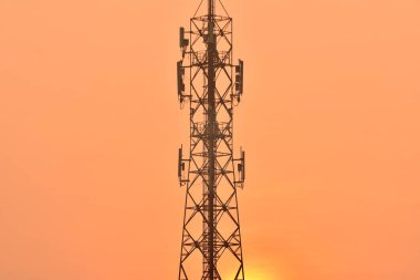 Kablosuz iletişim anteni ile parlak gökyüzü. Turuncu gökyüzü antenler ile telekomünikasyon Kulesi.