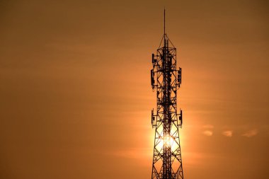 Kablosuz iletişim anteni ile gündoğumu parlak gökyüzü. Turuncu Gökyüzü antenler ile telekomünikasyon Kulesi.