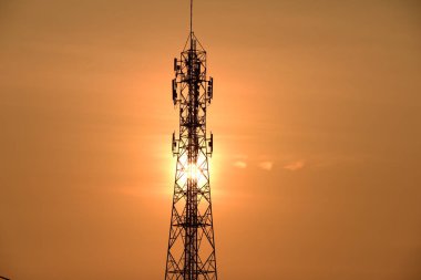 Kablosuz iletişim anteni ile gündoğumu parlak gökyüzü. Turuncu Gökyüzü antenler ile telekomünikasyon Kulesi.