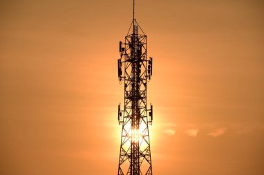  Kablosuz iletişim anteni ile gündoğumu parlak gökyüzü. Telekomünikasyon kule antenler ile portakal ile 