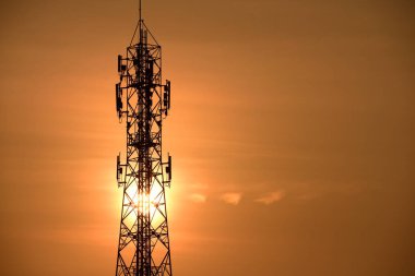 Kablosuz iletişim anteni ile gündoğumu parlak gökyüzü. Turuncu Gökyüzü antenler ile telekomünikasyon Kulesi.