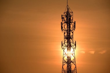Kablosuz iletişim anteni ile gündoğumu parlak gökyüzü. Turuncu Gökyüzü antenler ile telekomünikasyon Kulesi.