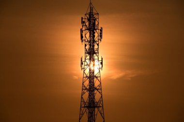 Kablosuz iletişim anteni ile gündoğumu parlak gökyüzü. Turuncu Gökyüzü antenler ile telekomünikasyon Kulesi.