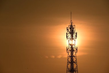 Kablosuz iletişim anteni ile gündoğumu parlak gökyüzü. Turuncu Gökyüzü antenler ile telekomünikasyon Kulesi.