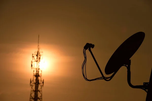 Wireless Communication Antenna With sunrise bright sky.Telecommunication tower with antennas with orange sky.