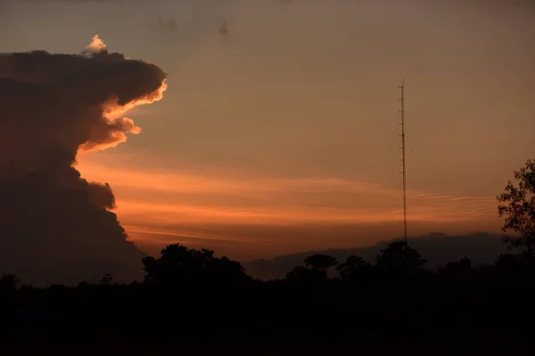 日没後 金色の雲 オレンジ 美しい形がゴッツィラに似た夕方の空 — ストック写真