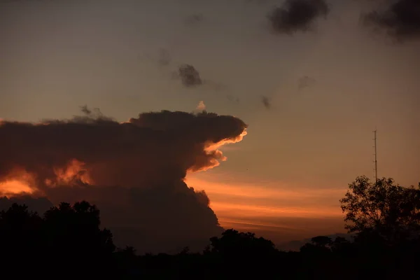 日没後 金色の雲 オレンジ 美しい形がゴッツィラに似た夕方の空 — ストック写真