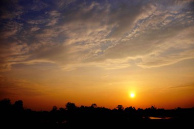 Alanın ortasında güzel altın gökyüzü günbatımı.