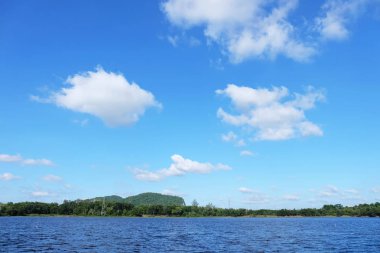 Göl Manzaralı orada ağaçlarıyla güzel bulutlar ve Yeşil dağlar vardır.