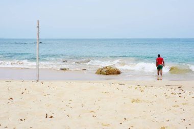 Güzel bir plaj, beyaz dalgalar, kayalar ve balıkçı tekneleri, esinti, güneş parlak gün ışığında beyaz kum plaj.