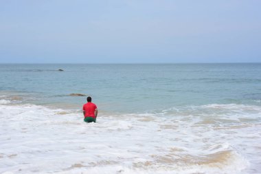 Güzel bir plaj, beyaz dalgalar, kayalar ve balıkçı tekneleri, esinti, güneş parlak gün ışığında beyaz kum plaj.