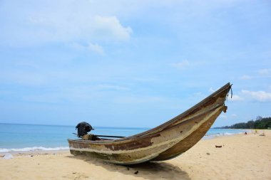 Güzel bir plaj, beyaz dalgalar, kayalar ve balıkçı tekneleri, esinti, güneş parlak gün ışığında beyaz kum plaj.