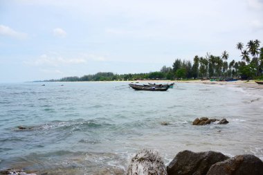 Güzel bir plaj, beyaz dalgalar, kayalar ve balıkçı tekneleri, esinti, güneş parlak gün ışığında beyaz kum plaj. Güzel bir plaj, temiz su, güzel plajları ve dalgalar. Güneşli bir günde