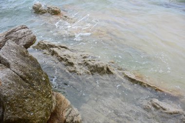 Güzel bir plaj, beyaz dalgalar, kayalar ve balıkçı tekneleri, esinti, güneş parlak gün ışığında beyaz kum plaj. Güzel bir plaj, temiz su, güzel plajları ve dalgalar. Güneşli bir günde