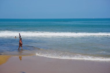 Güzel bir plaj, beyaz dalgalar, kayalar ve balıkçı tekneleri, esinti, güneş parlak gün ışığında beyaz kum plaj.