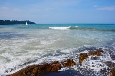 Güzel bir plaj, beyaz dalgalar, kayalar ve balıkçı tekneleri, esinti, güneş parlak gün ışığında beyaz kum plaj. Güzel bir plaj, temiz su, güzel plajları ve dalgalar. Güneşli bir günde