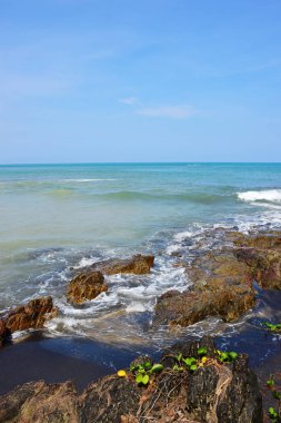 Güzel bir plaj, beyaz dalgalar, kayalar ve balıkçı tekneleri, esinti, güneş parlak gün ışığında beyaz kum plaj. Güzel bir plaj, temiz su, güzel plajları ve dalgalar. Güneşli bir günde