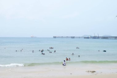 Turistler plajda yüzüyor. Ve kumlu plaj boyunca yürüyüş yapın. Şemsiye plajda, Sattahip, Chonburi, Tayland tarihinde 28 Nisan 2018 yağmur fırtına ile yağmurlu bir gün kullanmanız gerekir.