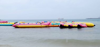 Turistler plajda yüzüyor. Ve kumlu plaj boyunca yürüyüş yapın. Şemsiye plajda, Sattahip, Chonburi, Tayland tarihinde 28 Nisan 2018 yağmur fırtına ile yağmurlu bir gün kullanmanız gerekir.