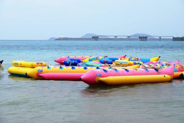 Turistler plajda yüzüyor. Ve kumlu plaj boyunca yürüyüş yapın. Şemsiye yağmurlu bir günde sahilde, Sattahip, Chonburi, Tayland tarihinde 28 Nisan 2018 kullanmanız gerekir.