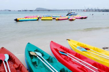 Seafront adlı tekne ve yağmurlu günde plajda kayık.