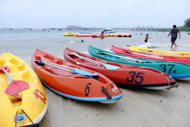 Turistler plajda yüzüyor. Ve kumlu plaj boyunca yürüyüş yapın. Şemsiye yağmurlu bir günde sahilde, Sattahip, Chonburi, Tayland tarihinde 28 Nisan 2018 kullanmanız gerekir.