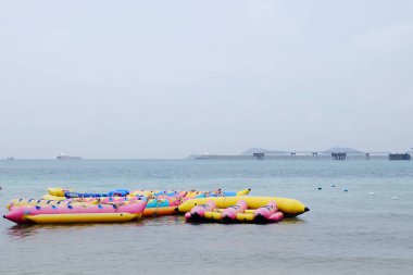 Turistler plajda yüzüyor. Ve kumlu plaj boyunca yürüyüş yapın. Şemsiye yağmurlu bir günde sahilde, Sattahip, Chonburi, Tayland tarihinde 28 Nisan 2018 kullanmanız gerekir.