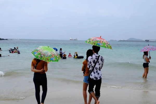 游客们正在海滩上游泳 沿着沙滩漫步 在下雨的日子里 必须用雨伞在海滩上淋雨 沙子玩具和玩具放在海滩上 下雨天在海滩上划独木舟 — 图库照片