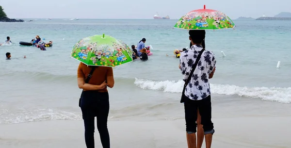 游客们正在海滩上游泳 沿着沙滩漫步 在下雨的日子里 必须用雨伞在海滩上淋雨 沙子玩具和玩具放在海滩上 下雨天在海滩上划独木舟 — 图库照片