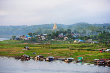 Turistler ve nehir görünümünü ve çevresindeki topluluklar barajın Pzt Bridge Khao Laem Barajı, Sangklaburi, Thailand.2018, 5 Mayıs oteller