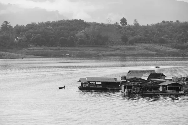 View of the river and surrounding communities of the dam near the Mon Bridge .water in the dams and boats, villagers and community residences. at Khao Laem Dam,