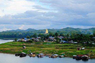 Gündoğumu veya günbatımı dağ, sabahın erken saatlerinde. Altın, güzel ve renkli gökyüzüdür. Sahne bir altın sarı gökyüzü güzel bulutlar, su barajlar ve tekneler, köylüler ve toplum konut vardır.