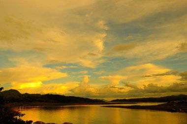 Renkli gökyüzü güneş önce akşam düşen zaman. Turistler ve nehir görünümünü ve çevresindeki topluluklar barajın Khao Laem Barajı, Sangklaburi, Thailand.2018 Mayıs Pzt Bridge yakınındaki