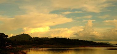 Gündoğumu veya günbatımı dağ, sabahın erken saatlerinde. Altın, güzel ve renkli gökyüzüdür. Güneş battığında, güneşin battığı. Toprak yol ve yeşil ağaçlar girişidir.