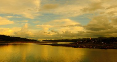 Renkli gökyüzü güneş önce akşam düşen zaman. Turistler ve nehir görünümünü ve çevresindeki topluluklar barajın Khao Laem Barajı, Sangklaburi, Thailand.2018 Mayıs Pzt Bridge yakınındaki