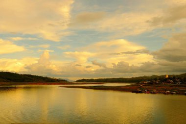 Renkli gökyüzü güneş önce akşam düşen zaman. Turistler ve nehir görünümünü ve çevresindeki topluluklar barajın Khao Laem Barajı, Sangklaburi, Thailand.2018 Mayıs Pzt Bridge yakınındaki