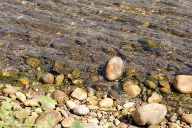 Güneşli bir günde taş nehir kıyısı