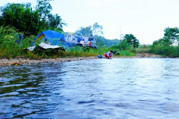 Me and family Tent camping in the rain forest near the stream in Sangkhlaburi, Kanchanaburi, Thailand on May 6, 2018.Sunrise over the stream at the tent campsite.Fish from the stream near the forest in Sangklaburi, Kanchanaburi, Thailand.