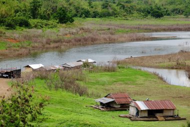Dağlar, gökyüzü, yeşil ormanlar arasında akarsu manzarası. Mavi gökyüzü ve parlak gün içinde güzel bulutlar.
