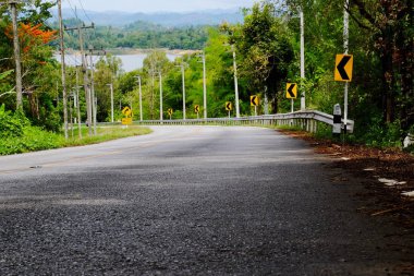 Dağ yolundan ağaçları ile. Manzaralı yoldan yeşil ağaçlar ve gökyüzü vardır. Tayland seyahat.